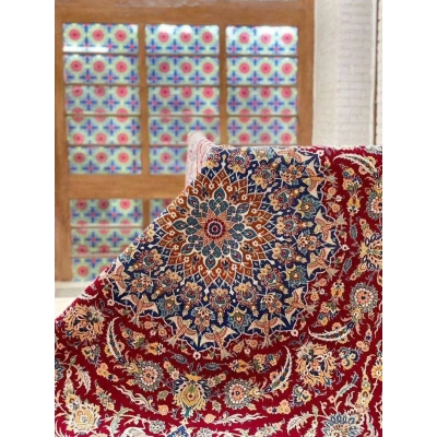 Luxurious Isfahan Persian carpet displayed on a table with red and blue patterns
