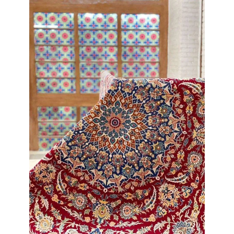 Luxurious Isfahan Persian carpet displayed on a table with red and blue patterns