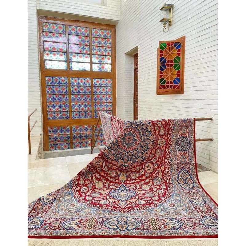 Isfahan Persian carpet spread out on the floor showcasing its red and blue design