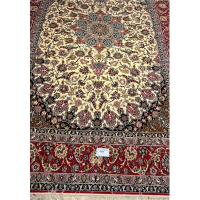 Hand-knotted wool and silk rug in ivory, red, and black.