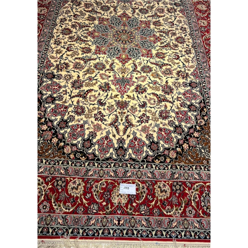Hand-knotted wool and silk rug in ivory, red, and black.