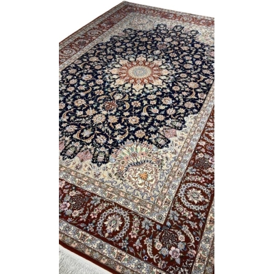 "Authentic Persian carpet from Isfahan, Iran, featuring a navy blue background and elaborate floral motifs."