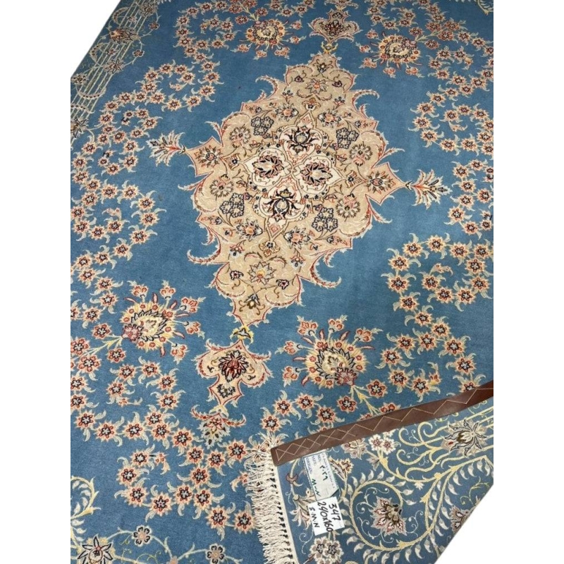 Hand-knotted Persian rug featuring intricate floral details on a blue base.