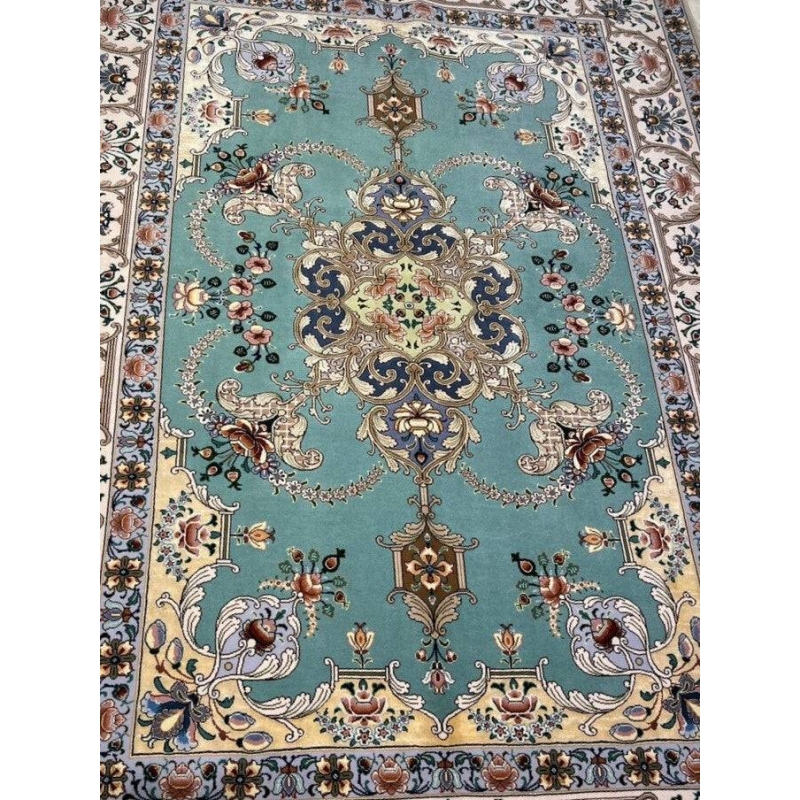 "Luxury Isfahan carpet in aqua, gold, and navy hues, featuring intricate floral patterns and silk accents."