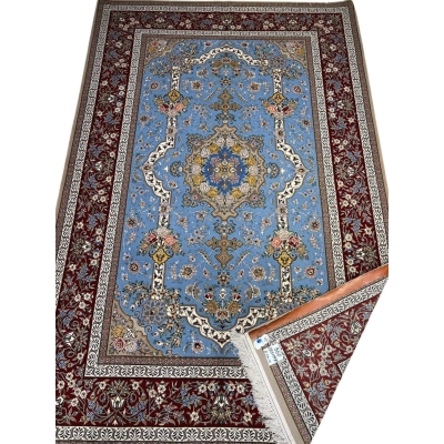 "Hand-knotted Persian Isfahan rug with a light blue floral field and burgundy border, crafted by Mansourie."
