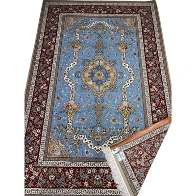 "Hand-knotted Persian Isfahan rug with a light blue floral field and burgundy border, crafted by Mansourie."
