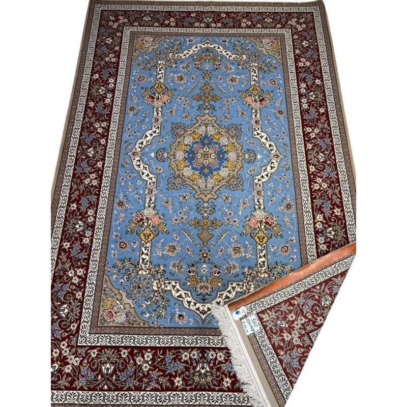"Hand-knotted Persian Isfahan rug with a light blue floral field and burgundy border, crafted by Mansourie."