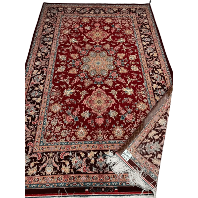 A detailed floral pattern on an Isfahan Persian rug with red and black hues