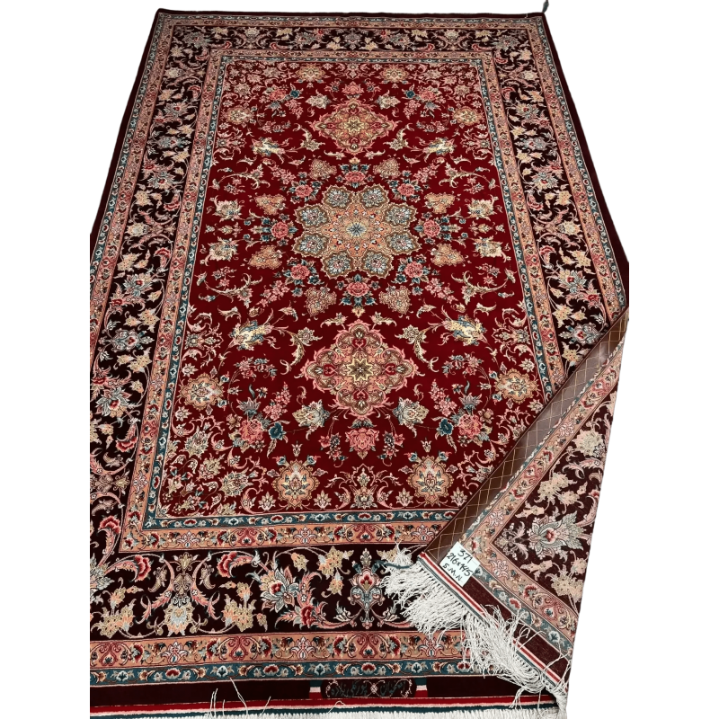 A detailed floral pattern on an Isfahan Persian rug with red and black hues