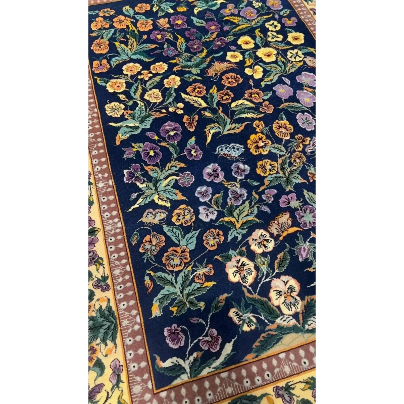 Hand-knotted wool and silk rug with a navy-blue base.
