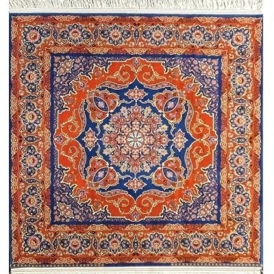 Round Isfahan rug featuring a medallion design in vibrant orange and royal blue, handcrafted by Master Nasrollah Haghighie.
