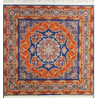 Round Isfahan rug featuring a medallion design in vibrant orange and royal blue, handcrafted by Master Nasrollah Haghighie.
