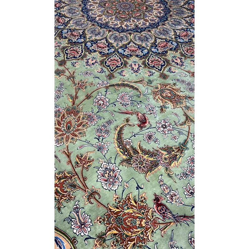 "Close-up of the light green silk field and detailed floral motifs on the Persian rug."