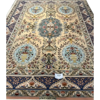 "Handmade Persian rug by Master Moeidie with intricate floral designs in soft beige and pastel tones."
