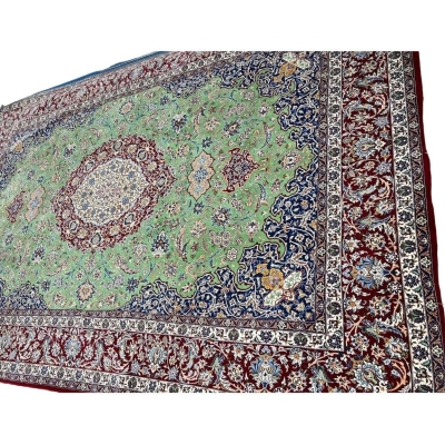 "Close-up of traditional design in master oriental weaver rug, green and red hues"