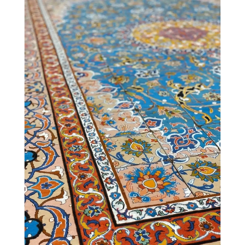 "Close-up of a Persian rug’s intricate border design, featuring vibrant floral and geometric motifs in blue, orange, and gold."