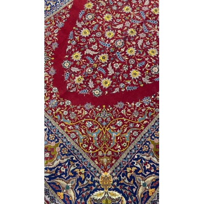 "Detailed view of antique red rug from Isfahan with intricate floral motifs"
