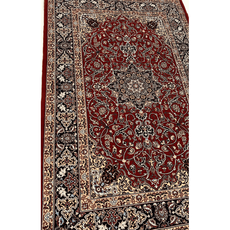 "Close-up of a hand-knotted Seirafian Persian rug, showcasing intricate floral and medallion designs in red, blue, and beige, made from silk and wool."