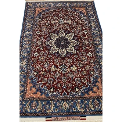 "Handwoven Seirafian silk carpet with floral design, crafted by Master Ahmad Seirafian in Isfahan, featuring intricate patterns in silk and wool."
