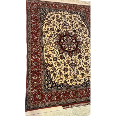 "Detailed view of the medallion design on a Seirafian Persian carpet, showcasing hand-knotted craftsmanship in red and beige tones."