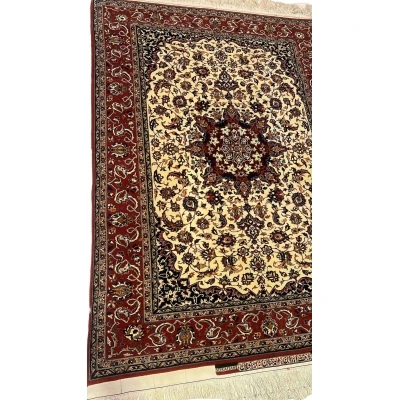 "Detailed view of the medallion design on a Seirafian Persian carpet, showcasing hand-knotted craftsmanship in red and beige tones."