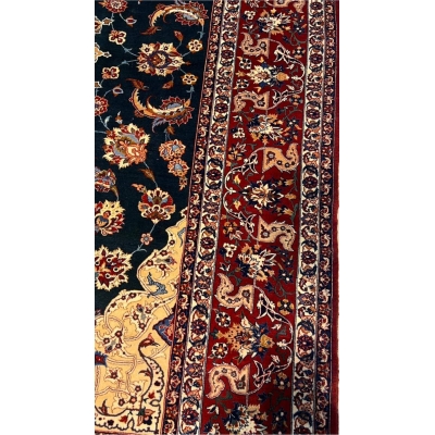 "Handcrafted wool and silk Persian rug with emerald green, gold, and red accents."