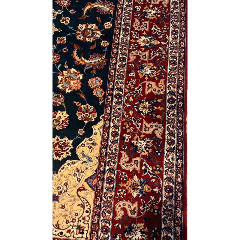 "Handcrafted wool and silk Persian rug with emerald green, gold, and red accents."