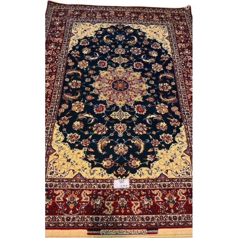 "Vintage hand-knotted Isfahan rug with a green field, yellow corners, and red borders by Ahmad Seirafian."