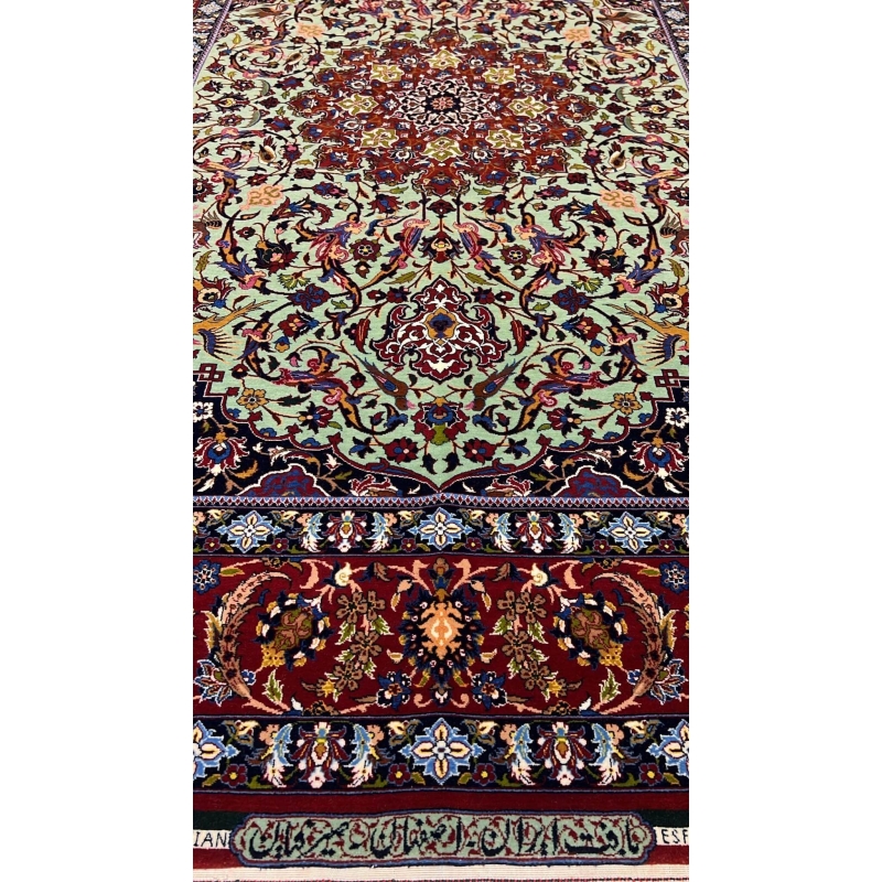 "Close-up of the Seirafian hand-knotted Persian rug with vibrant green and red tones, crafted in Isfahan."