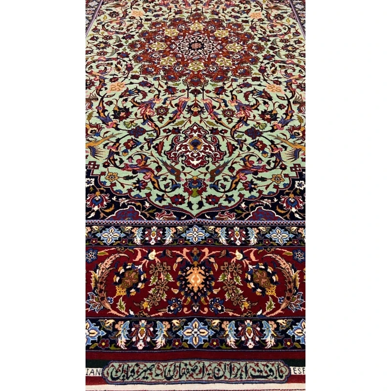 "Close-up of the Seirafian hand-knotted Persian rug with vibrant green and red tones, crafted in Isfahan."