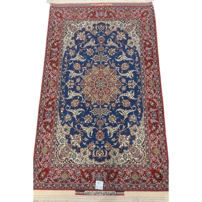 Hand-knotted Persian Seirafian rug with a deep blue medallion and red border.

