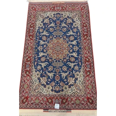 Hand-knotted Persian Seirafian rug with a deep blue medallion and red border.
