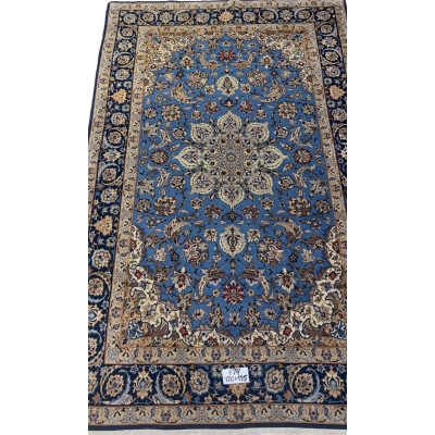 "Hand-knotted blue Persian rug from Isfahan, 170x115 cm, showcasing intricate floral and medallion designs in a wool and silk blend."
