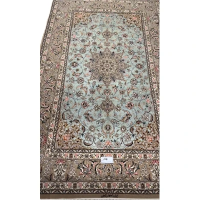 Hand-knotted Isfahan rug with a mint-green base and floral medallion.
