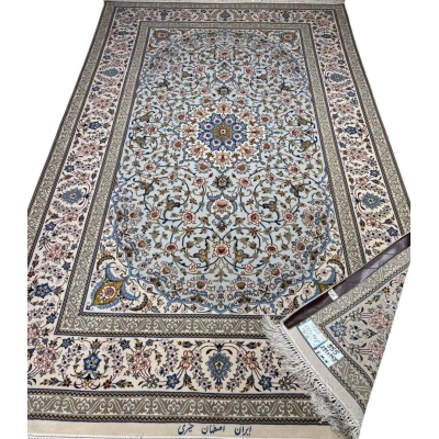 Hand-knotted Isfahan rug with a blue base and intricate floral medallion.
