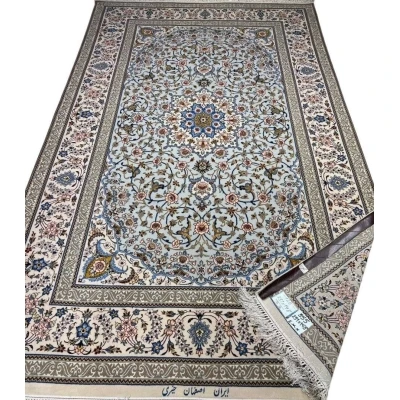 Hand-knotted Isfahan rug with a blue base and intricate floral medallion.