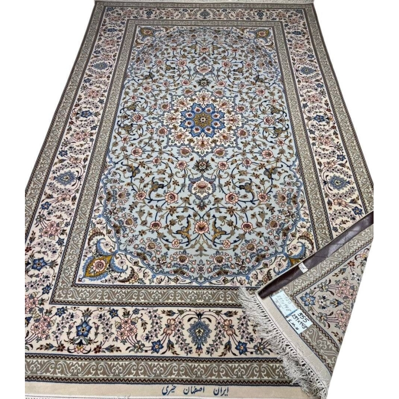 Hand-knotted Isfahan rug with a blue base and intricate floral medallion.