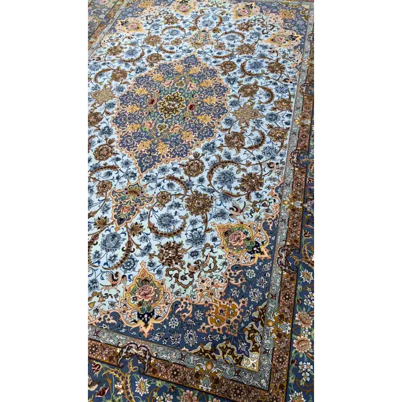 "Close-up of intricate floral designs on a light blue wool and silk Persian carpet."