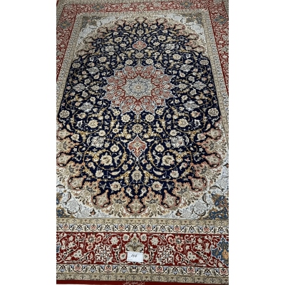 Handmade Persian Carpet from Isfahan – A full view of an elegant Persian carpet with a striking navy-blue field and intricate floral medallion design in red and ivory, hand-knotted with silk and wool by skilled artisans from Isfahan.

