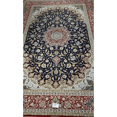 Handmade Persian Carpet from Isfahan – A full view of an elegant Persian carpet with a striking navy-blue field and intricate floral medallion design in red and ivory, hand-knotted with silk and wool by skilled artisans from Isfahan.

