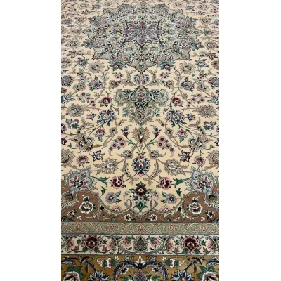 Close-up of the floral design on a beige hand-knotted Iranian rug