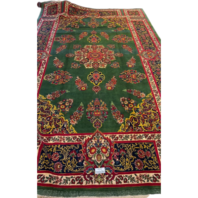 An expansive Mashad rug with intricate patterns and a golden border
