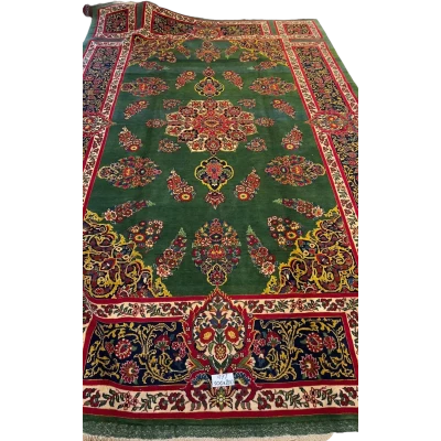 An expansive Mashad rug with intricate patterns and a golden border