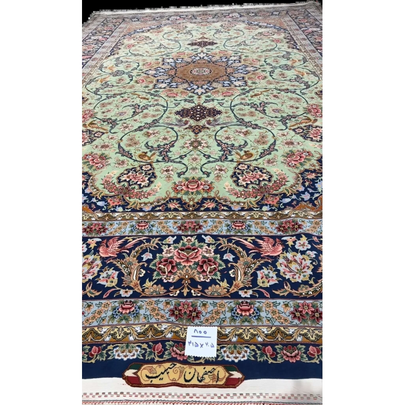 Light green Iranian handmade carpet with intricate patterns on display