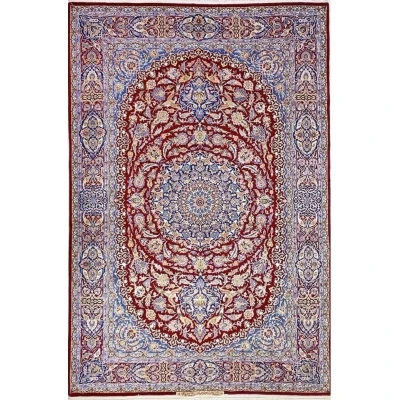 Detailed view of the Isfahan Persian carpet's central medallion with intricate floral patterns in red, blue, and ivory.

