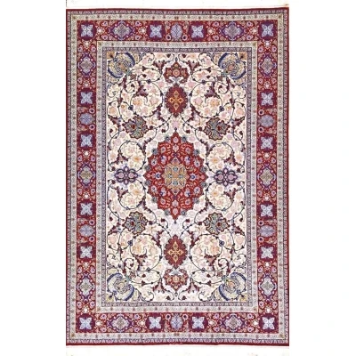 Detailed view of Ghenaat Isfahan handmade rug showcasing intricate floral motifs with red, blue, and cream tones.

